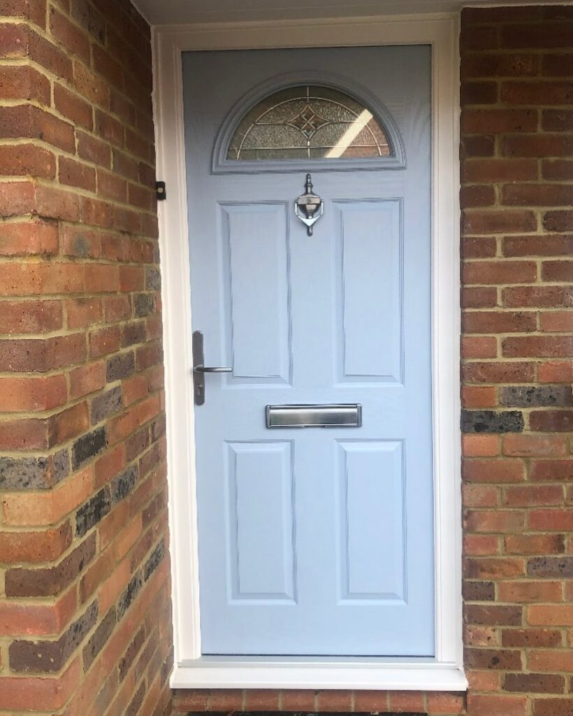 Picture of a porcelain blue coloured domestic replacement front door with upper double-glazed, leaded light glass window, stainless steel hardware including door knocker and letter box plate.